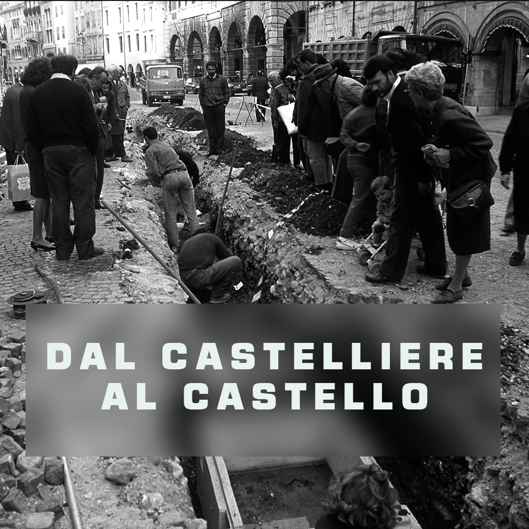 Fotografia scattata negli anni '80 in occasione delle indagini archeologiche in via Mercatovecchio a Udine che ritrae alcuni cittadini curiosi e gli archeologi impegnati nell'attività di scavo.